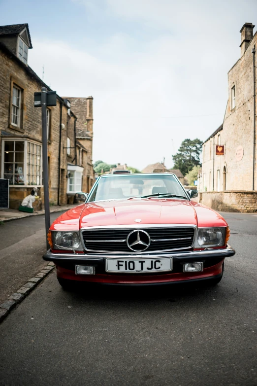 a classic mercedes is parked in front of a building