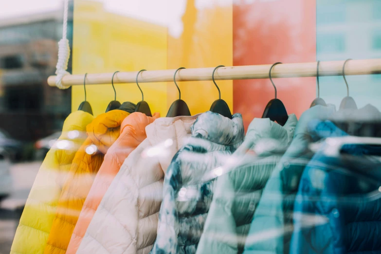 there are various coats displayed on a rack