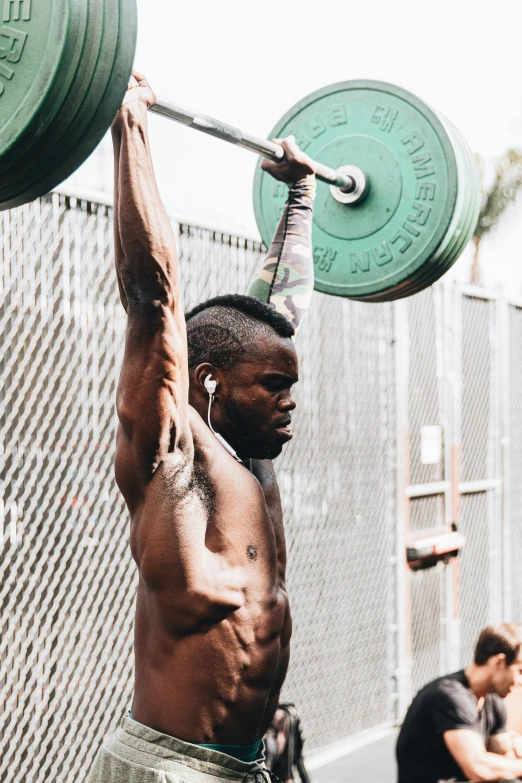 a man lifts a barbell with both hands