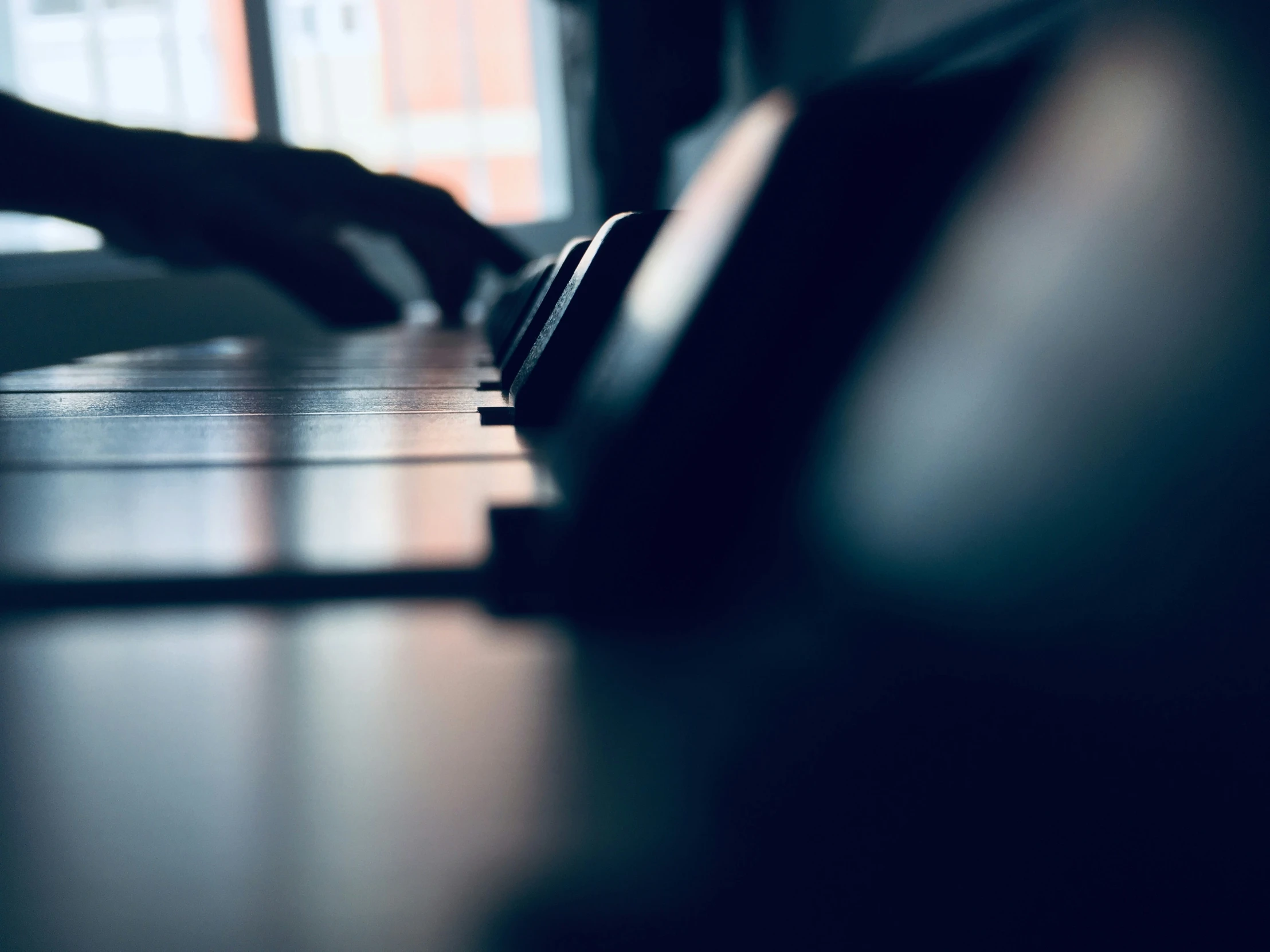 hand on keyboard in a room with dark light