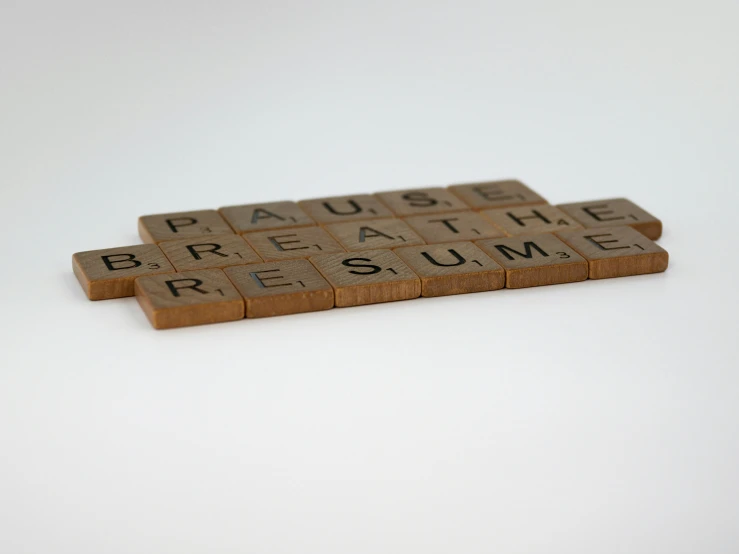 some type of scrabble style board that has the words pause breathe resume written on it