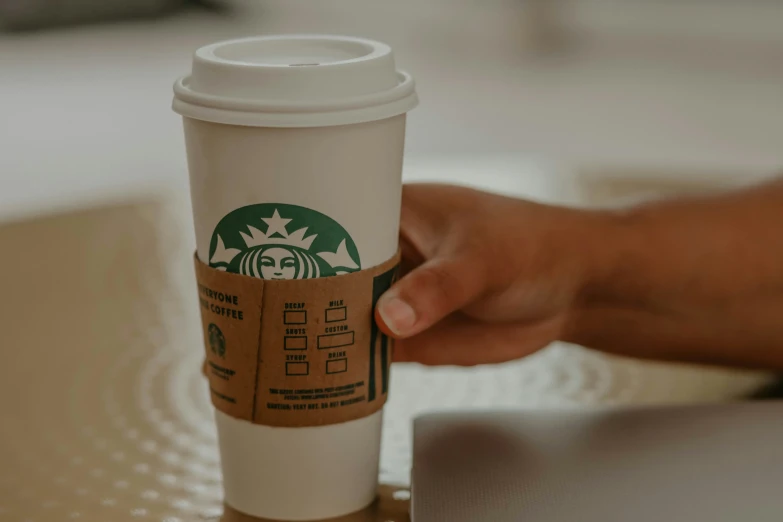 someone holding up the top of a starbucks cup