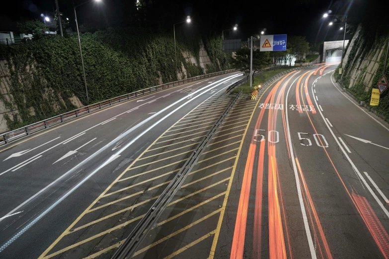 a highway at night with many lights lit up in the background