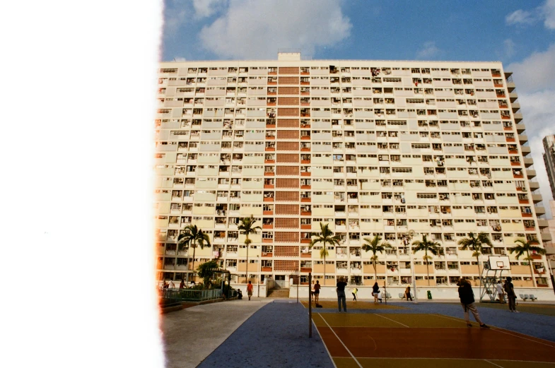 people are playing tennis in a court by a building