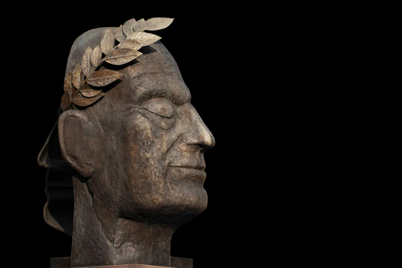 a carved wooden head on a black background