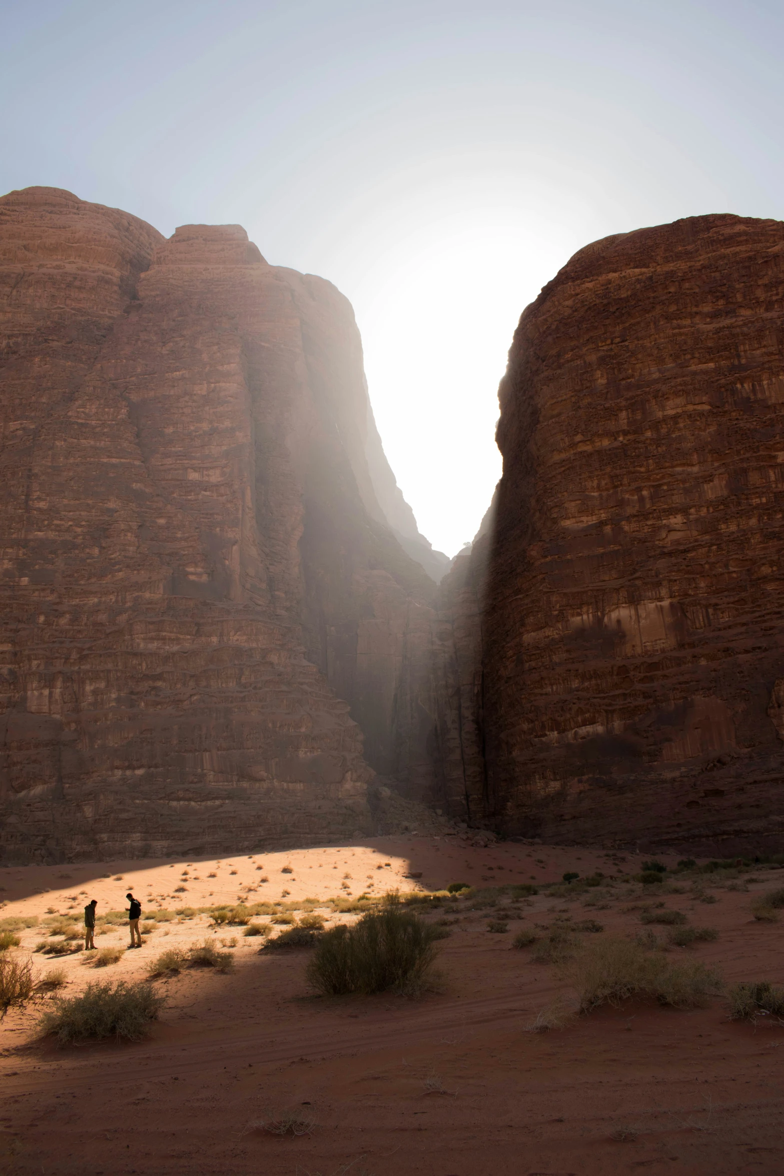 three people are walking through a rocky area