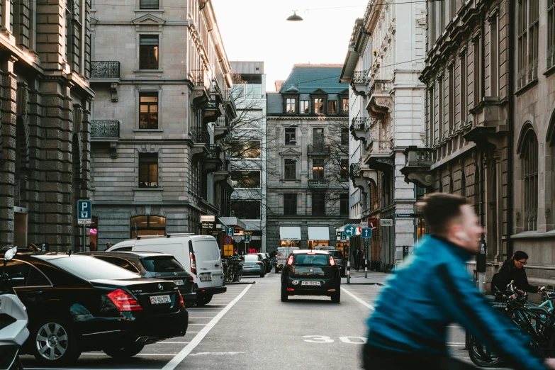 people ride bicycles down an old city street