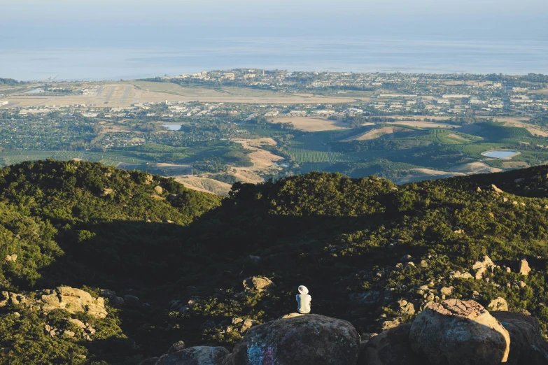 two statues are in the middle of a cliff overlooking a valley