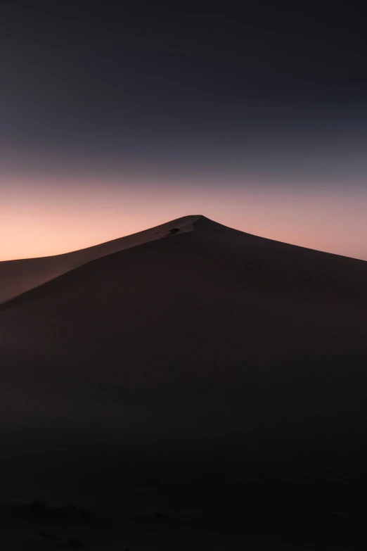 a distant mountain sits on top of the desert