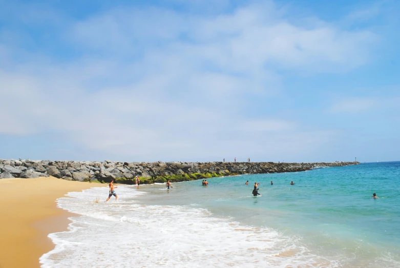 a group of people stand on the beach as they swim