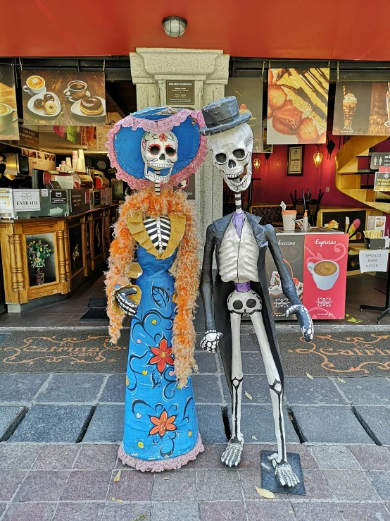 a skeleton statue standing next to a woman in a dress