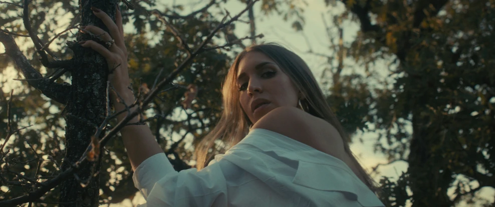 a woman looking up into the trees outside