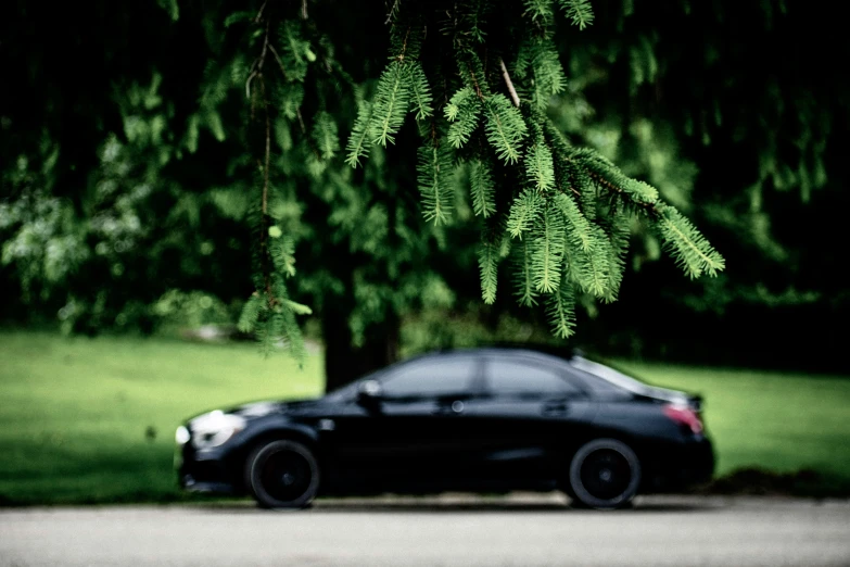 a dark colored vehicle parked near some trees