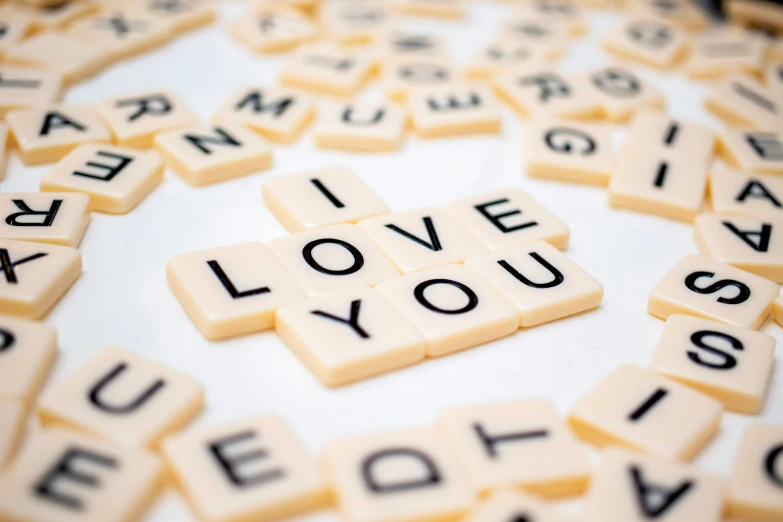 a table with scrabbles spelling the words, i love you