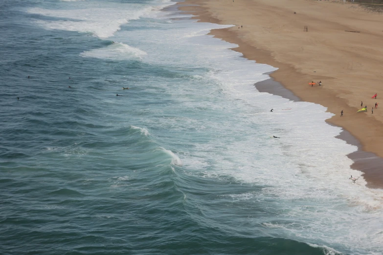 a sandy beach and body of water with people in the ocean