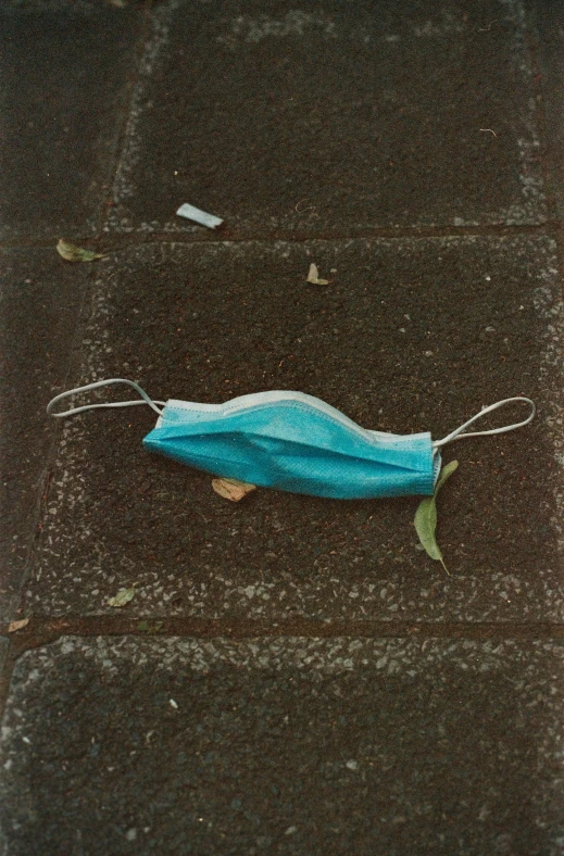 a blue cloth covered object is laying on the sidewalk