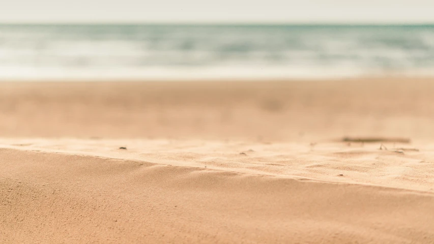 the view from a sand covered beach looking at water