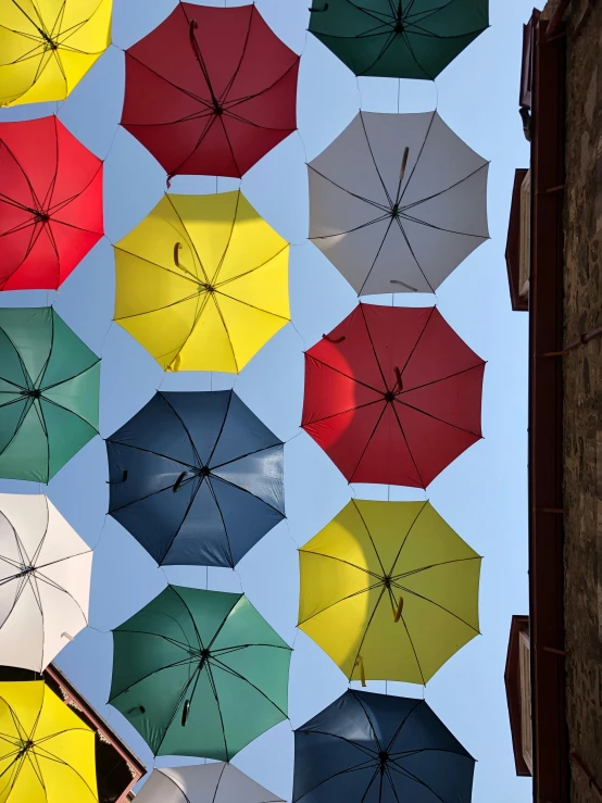 a bunch of umbrellas hanging up in the air