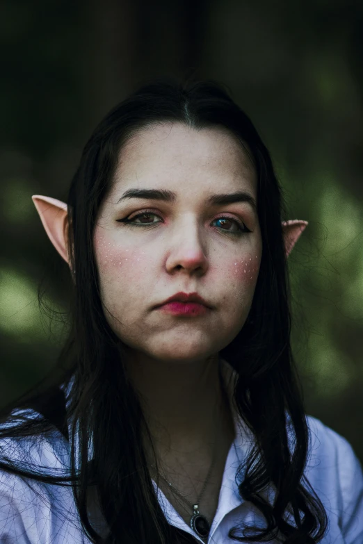 a  wearing an elf's ears is staring into the camera
