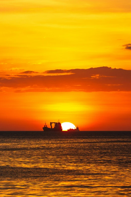 a boat is in the water as the sun sets