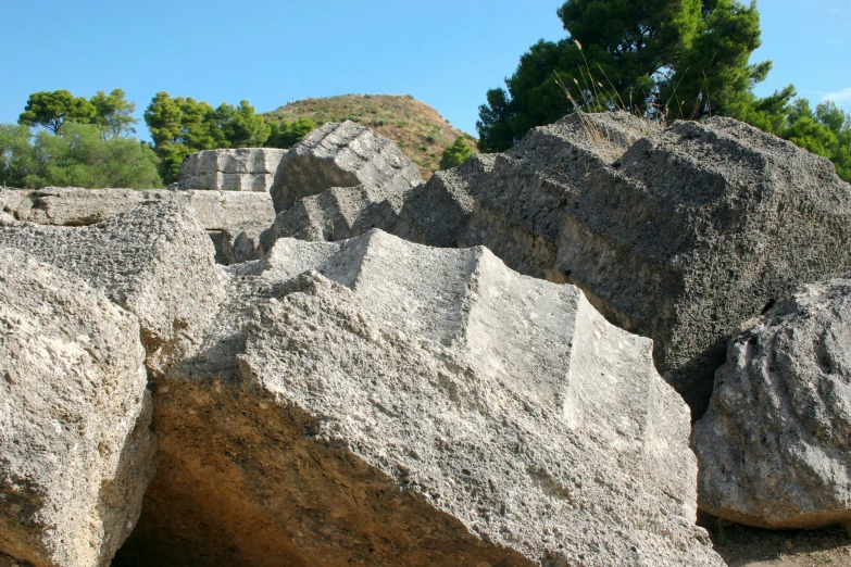 a couple of large rocks with trees in the background