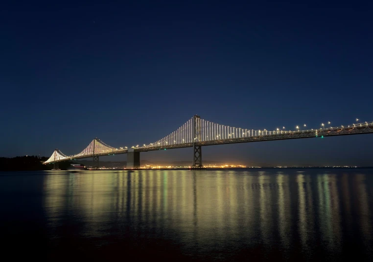 a long bridge over water with lights on it