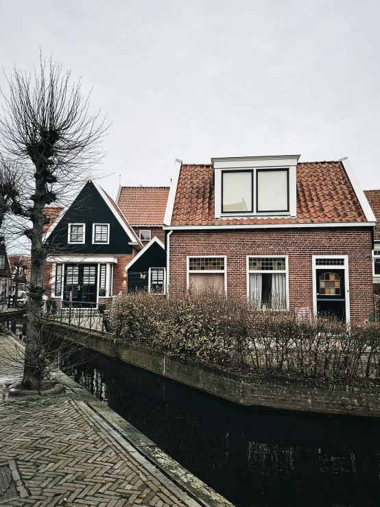 a house and trees sitting along side of a canal