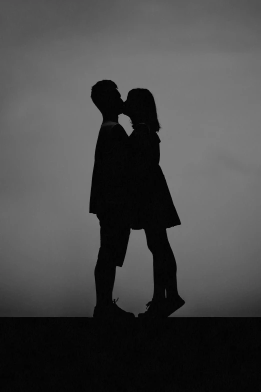 two people standing next to each other with a sky in the background