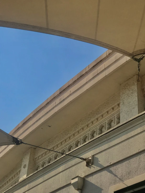 an old building with a sign on the side and an umbrella in front