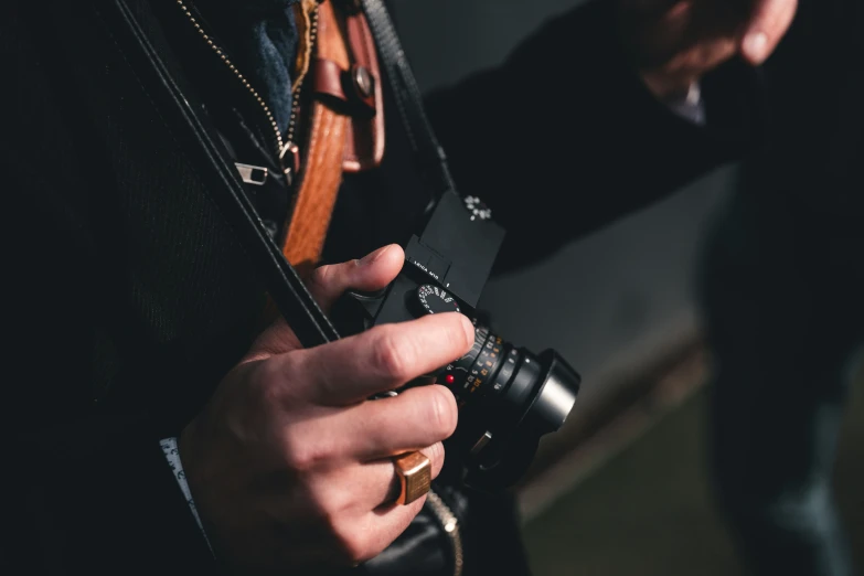 the hands of a man who is holding an old camera