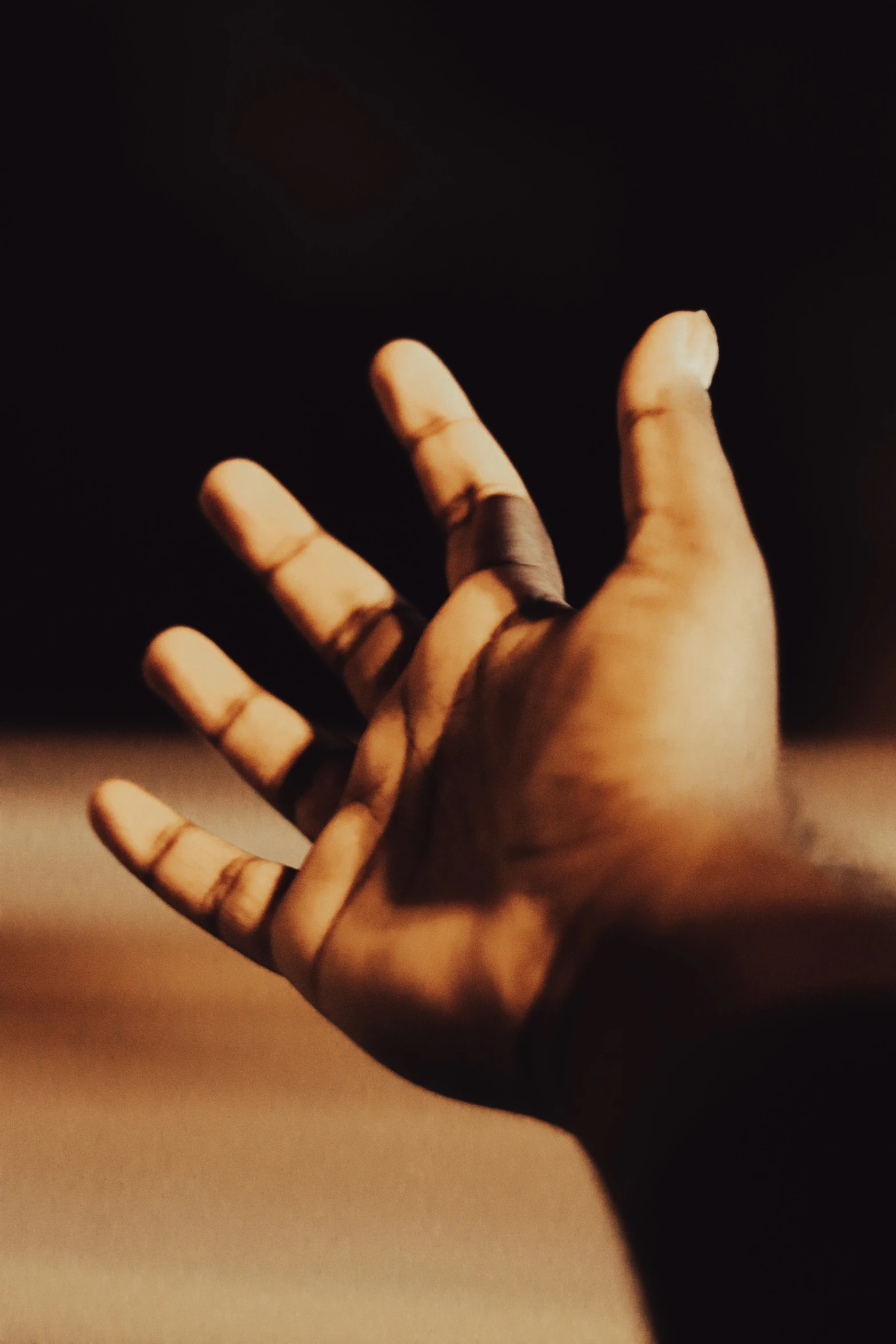 a hand reaching up into the air on the top of a table