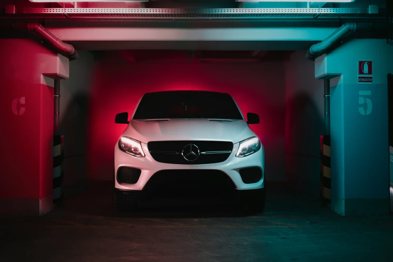 a white car parked in a garage in the dark