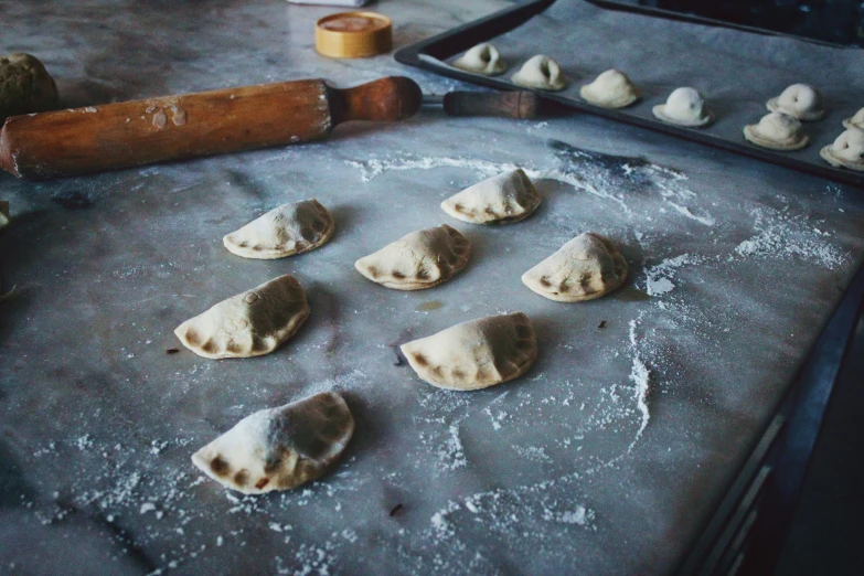 small dumplings on a baking sheet being doughed