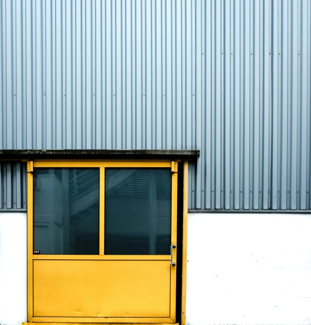 a building has a blue wall and a yellow door