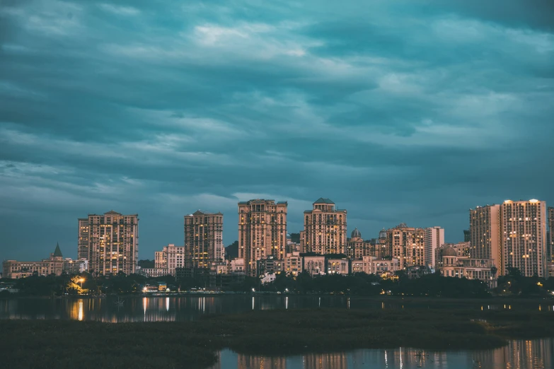 city with light towers by a river at dusk