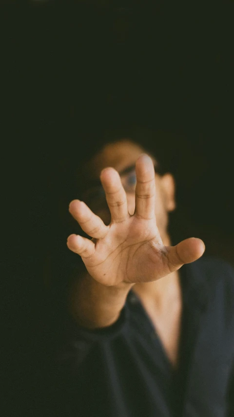 a blurry image of a hand with an outstretched gesture