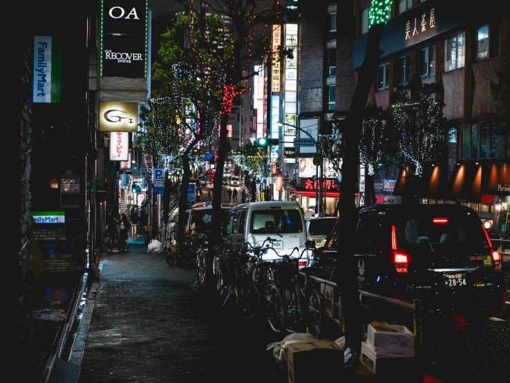 a street lined with lots of parked cars under lights