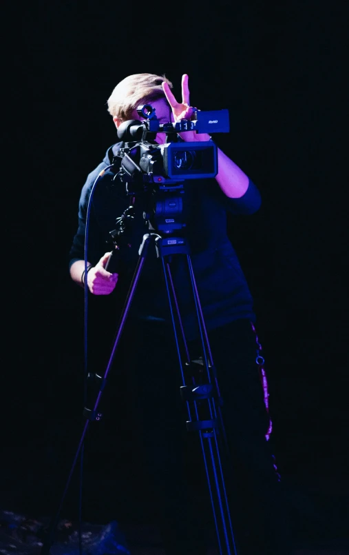 man standing on a stage while holding a video camera