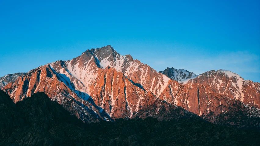 a mountains top under a blue sky with no clouds