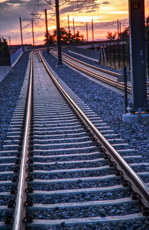 train tracks leading to an empty area with a sky