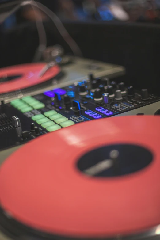 two turntables sitting next to each other with a red ribbon