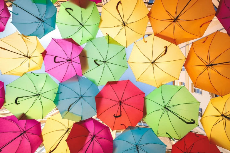 a group of brightly colored umbrellas floating in the air