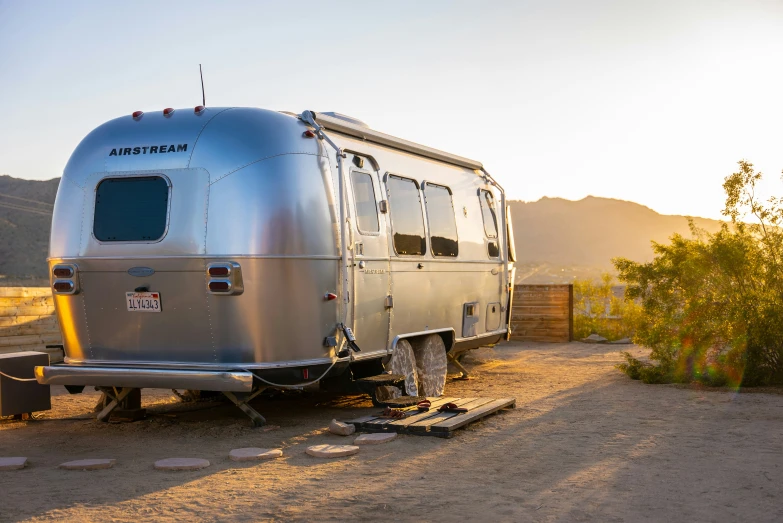 a silver trailer is parked outside in a desert