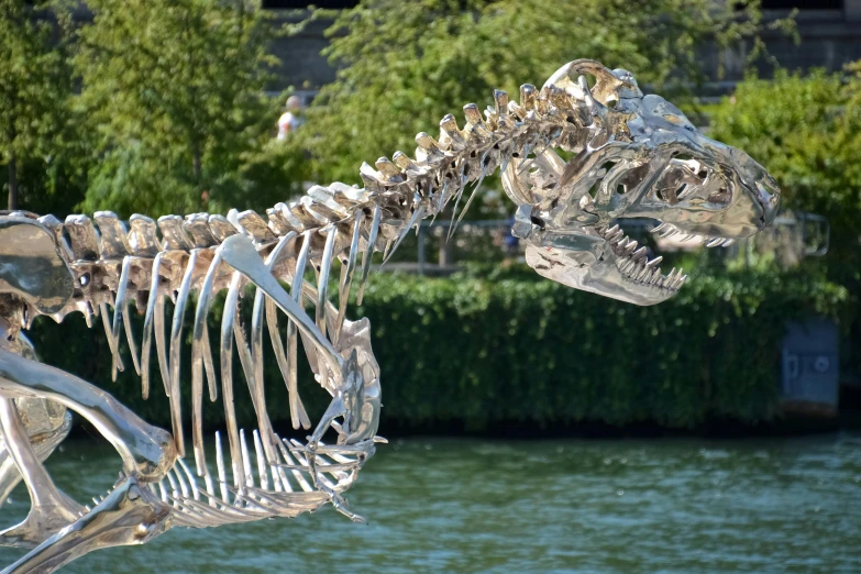 a statue of a t - bone being displayed in front of a lake