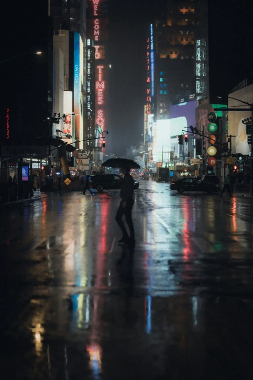 the person walks on the city street with an umbrella