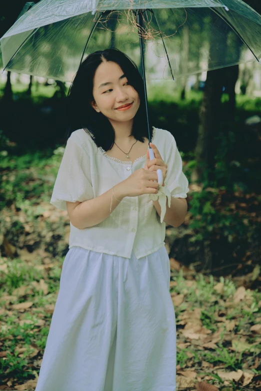 a woman holding an umbrella in a forest