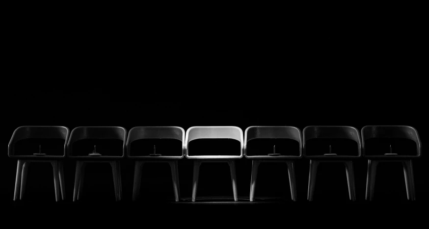 five chairs in a row on a black background