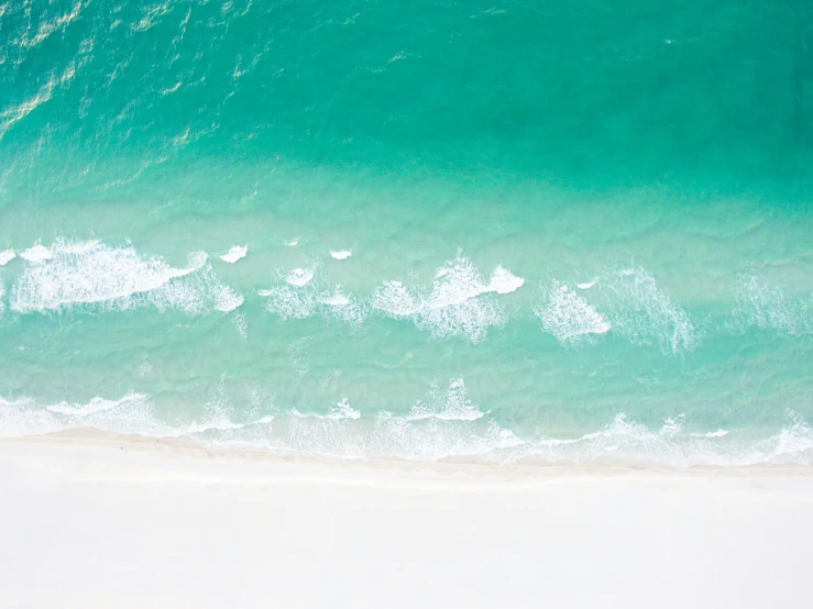 this is an aerial po of the ocean and its white sand beach