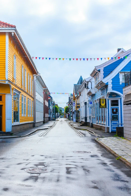 a narrow street with colorful houses and a long banner