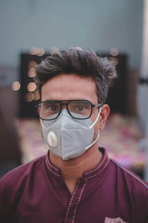 the young man in glasses has a protective face mask